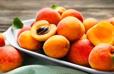 Plate with ripe sweet apricots on table, closeup