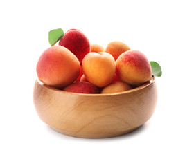 Wooden bowl with ripe sweet apricots on white background
