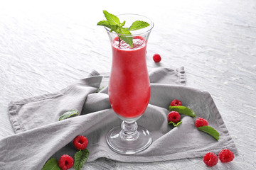 Glass of tasty raspberry smoothie on table