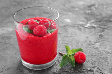 Glass of tasty raspberry smoothie on table