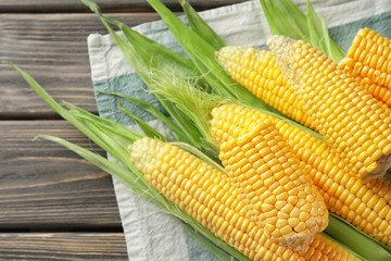 Fresh corn cobs on wooden background