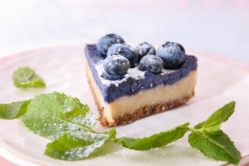Piece of tasty cheesecake with blueberries on plate, closeup