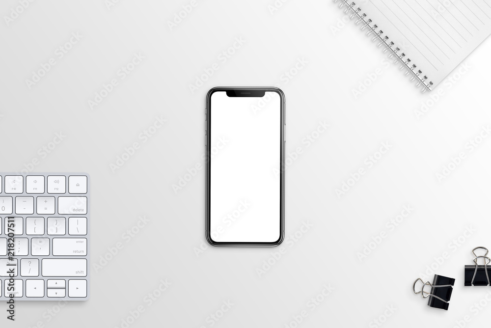 Aufkleber Modern smart phone with blank, white, isolated screen for mockup on flat, simple desk with keyboard, notepad and poster clips. Top view.