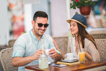 Beautiful loving couple sitting in a cafe enjoying in coffee and conversation