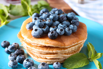 Tasty pancakes with blueberries on plate, closeup