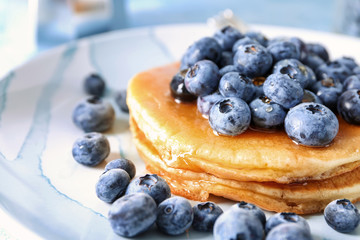 Tasty pancakes with blueberries on plate, closeup