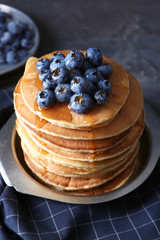 Plate with tasty pancakes and blueberries on table