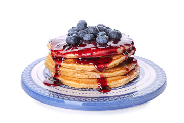 Plate with tasty pancakes, jam and blueberries on white background