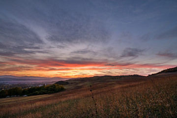 Romantic, bright and colorful sunset over a mountain range in Transilvania. Beautiful, colorful autumn background