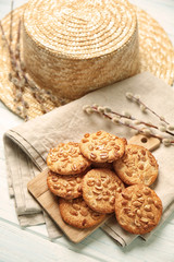 Board with delicious cookies and hat on white wooden table