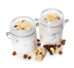 Glass jars with delicious rice pudding, raisins and nuts on white background