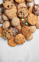 Different delicious cookies on white wooden table