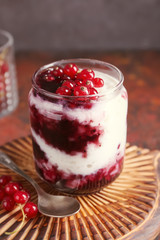 Glass jar with delicious rice pudding and currants on board