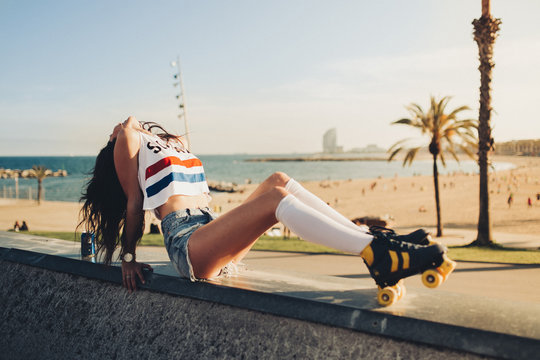 Young vintage brunette girl posing and smiling in a sunset on the streets of Barcelona