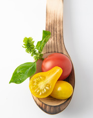 Homemade tomatoes from the meadow to the table are natural mixes of different colors and sizes. Presented on a board and a spoon.