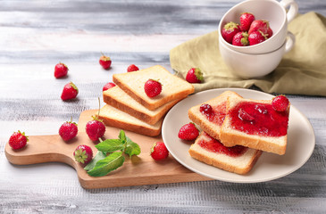 Composition with slices of bread and delicious strawberry jam on wooden table