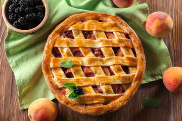 Delicious peach pie and blackberry on wooden table