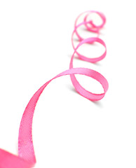 Fototapeta premium Curled pink ribbon on white background