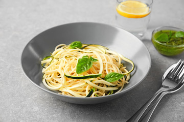 Plate of spaghetti with zucchini on table