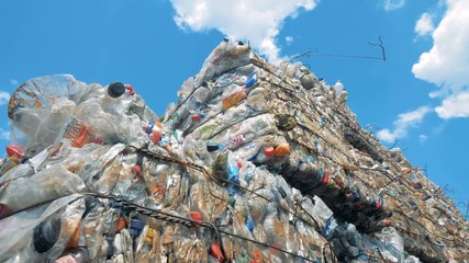 Used plastic bottles storaged in pressed blocks outdoors ready for recycling. Waste recycling concept. - Powered by Adobe