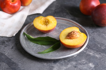 Plate with fresh peaches on table