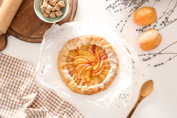 Delicious peach galette with products on light table