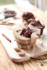 Board with tasty muffins on wooden table