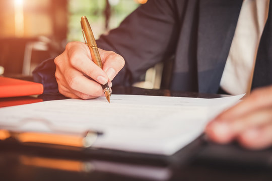 Close up business man reaching out sheet with contract agreement proposing to sign.Full and accurate details, individual who owns the business sign personally,director of the company, solicitor.