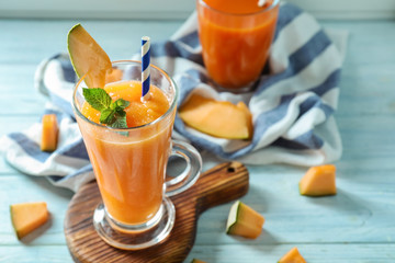 Glass of fresh melon smoothie on board