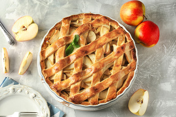 Board with delicious apple pie on light table
