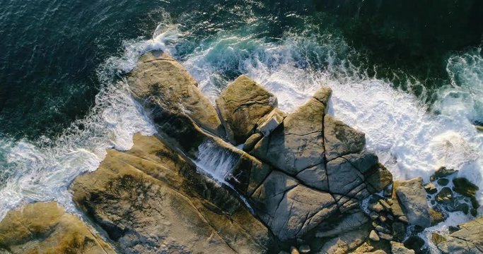 Drone descending over rugged coastline near Bicheno, Tasmania, Australia.