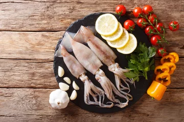 Fotobehang Fresh raw squid with tentacles closeup and vegetable ingredients. horizontal top view from above © FomaA