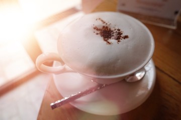 smooth milk foam on the top of cappuccino served , Cappuccino with cocoa and chocolate muffin.