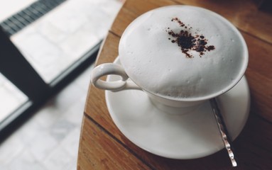 smooth milk foam on the top of cappuccino served , Cappuccino with cocoa and chocolate muffin.