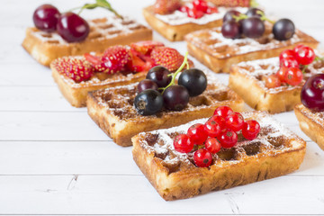 Homemade waffles with summer berries on a light table. Selective focus