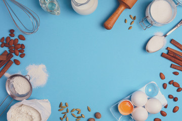 Baking ingredients for homemade pastry on blue background. Bake sweet cake dessert concept. Top view. Flat lay. Copy space. Toned