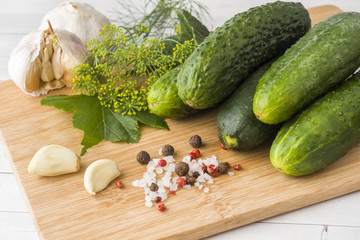 Marinated cucumbers, garlic and spices for salting on the wood surface.