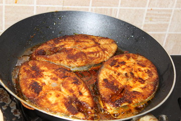 Seer fish being fried in Indian style on a metal pan. Also known as King fish.
