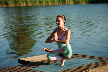 Young healthy woman practicing yoga at sunset