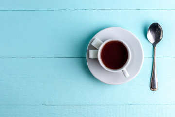 A cup of coffee on a blue, wooden background. Awakening, morning. Copy space. Top view