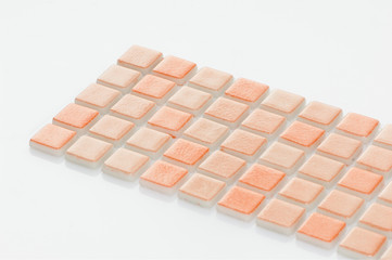 little orange ceramic tile on a white background, majolica. for the catalog