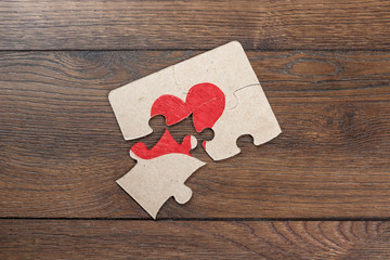 Parts of the puzzle form the heart, broken. The concept of divorce, quarrel, conflict.
