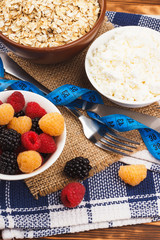 Oatmeal in the bowl with red and yellow raspberries