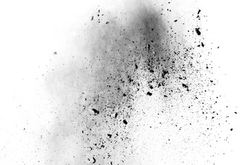 Black powder explosion. Closeup of black dust particles explode isolated on white background.