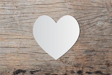 Fototapeta na wymiar White heart paper on old wooden for valentine's day message