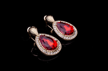 gold earrings with ruby drops isolated on black - 218224928