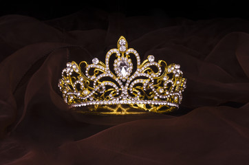gold crown with diamonds isolated on the fabric