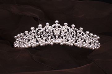 silver diadem with diamonds and pearls isolated on the fabric