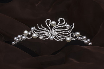 silver diadem with swans isolated on the fabric