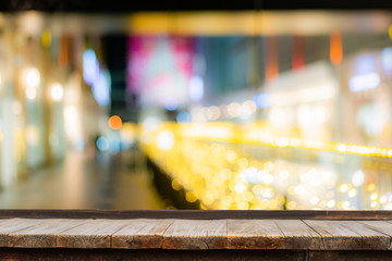 Selective focus of wooden table in front of decorative indoor string lights. Christmas, festival and holiday concepts, can used for display or montage your products.
